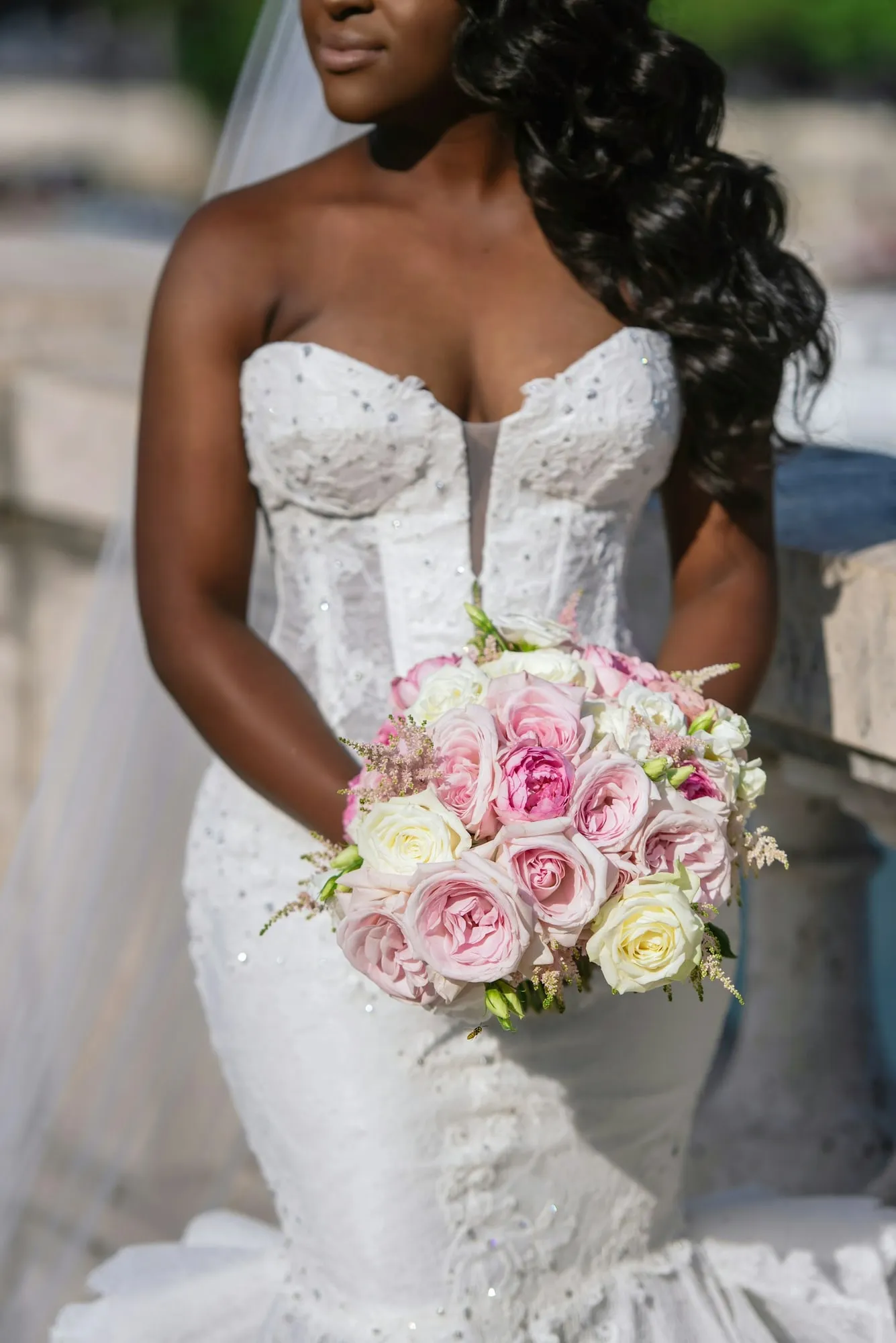 La mariée en bustier brodé, bouquet de roses à la main
