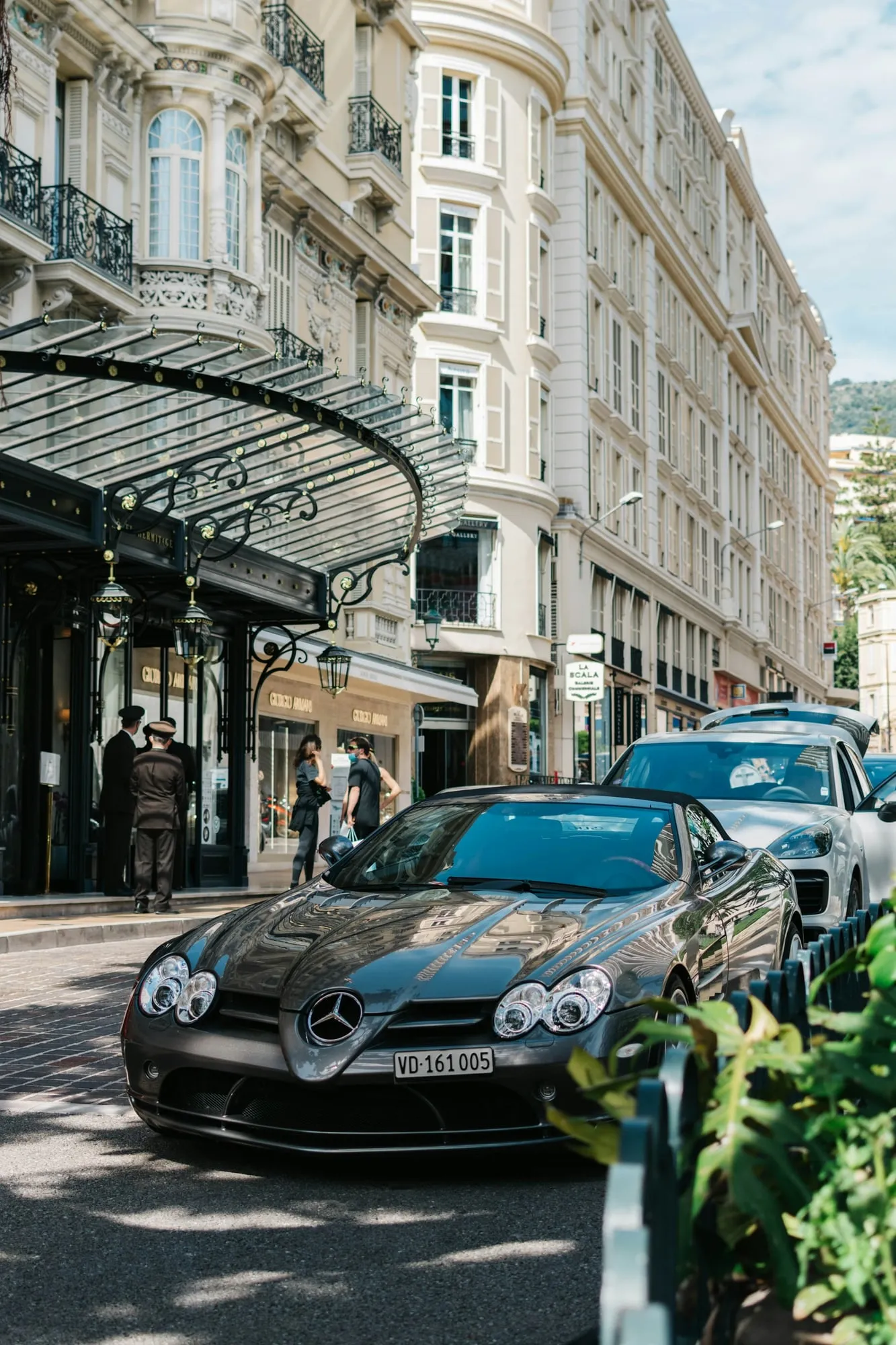 Façade d’un palace à Monaco, voiture de sport devant l’entrée